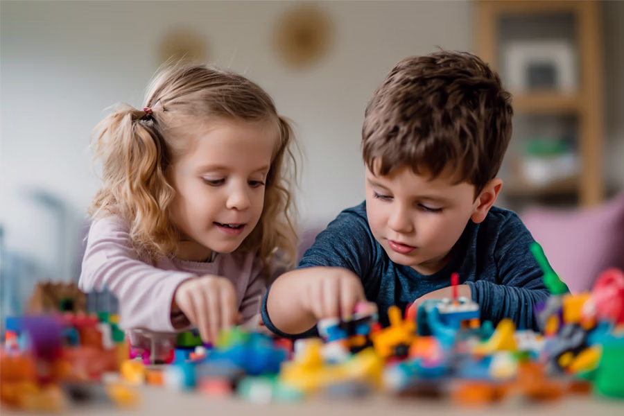 young boy and young girl playing with colored blocks